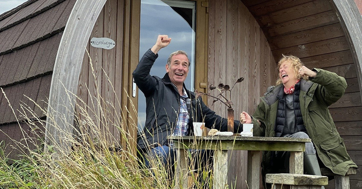 Robson Green and Charlie Hardwick laughing sat outside glamping hut on Durham Heritage Coast © BBC